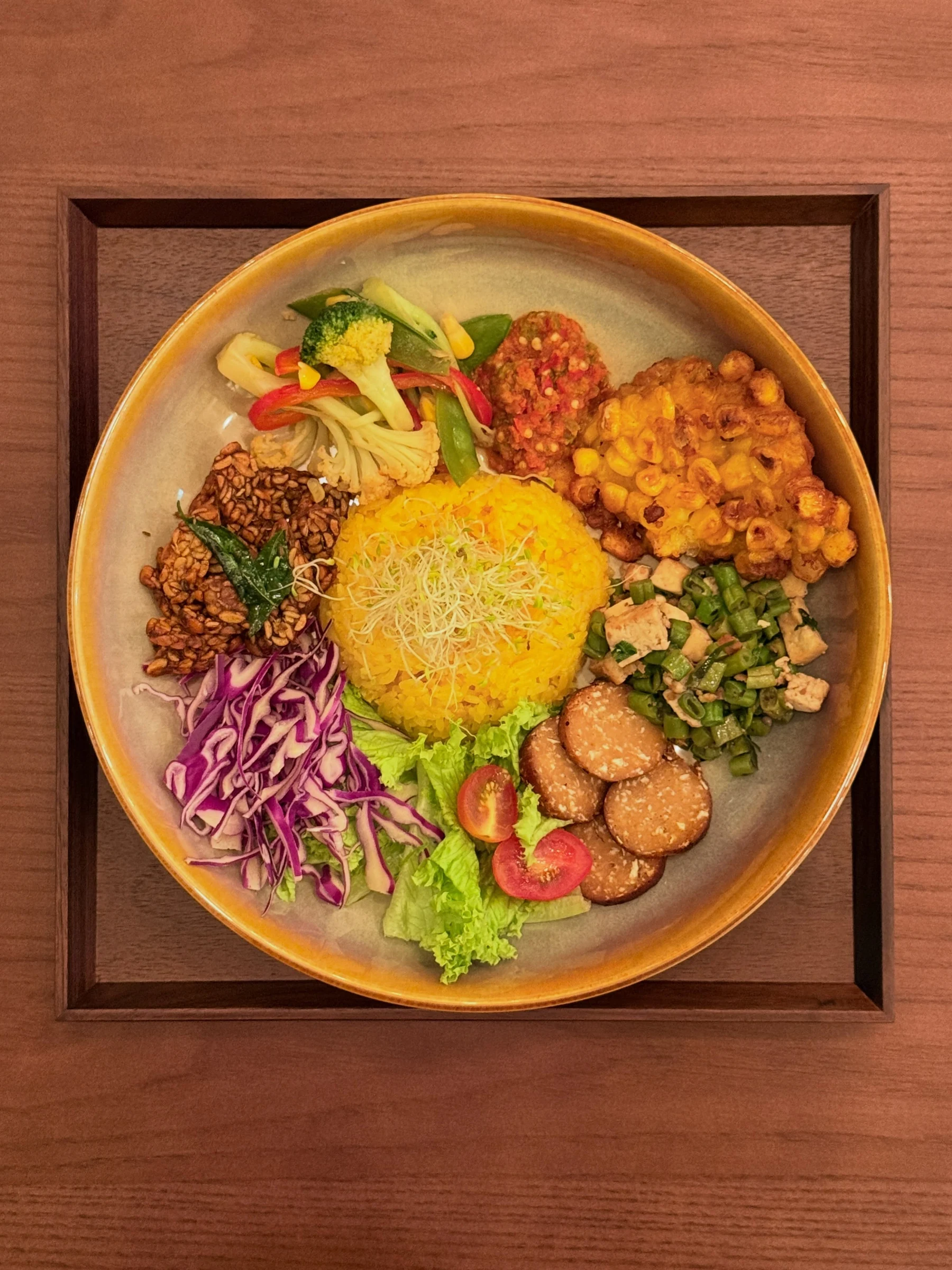 Colourful turmeric rice set with tempeh, tofu and fresh vegetables